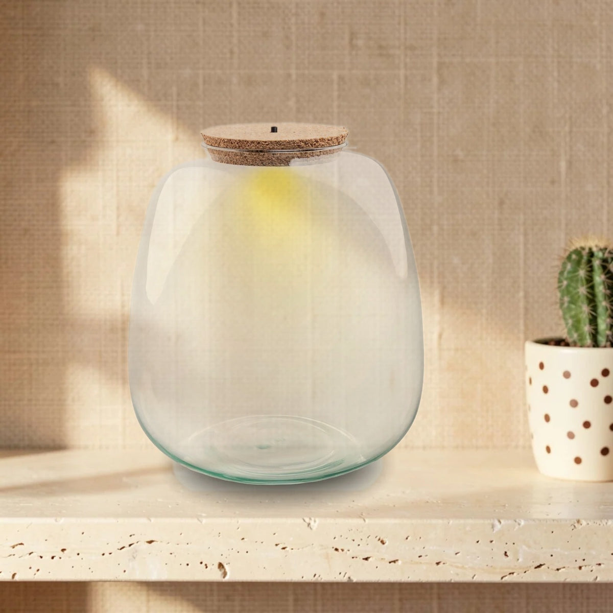 Flaschengarten-Glas „Emma“ mit LED-Korken – leer, auf hellem Steinregal vor beiger Wand